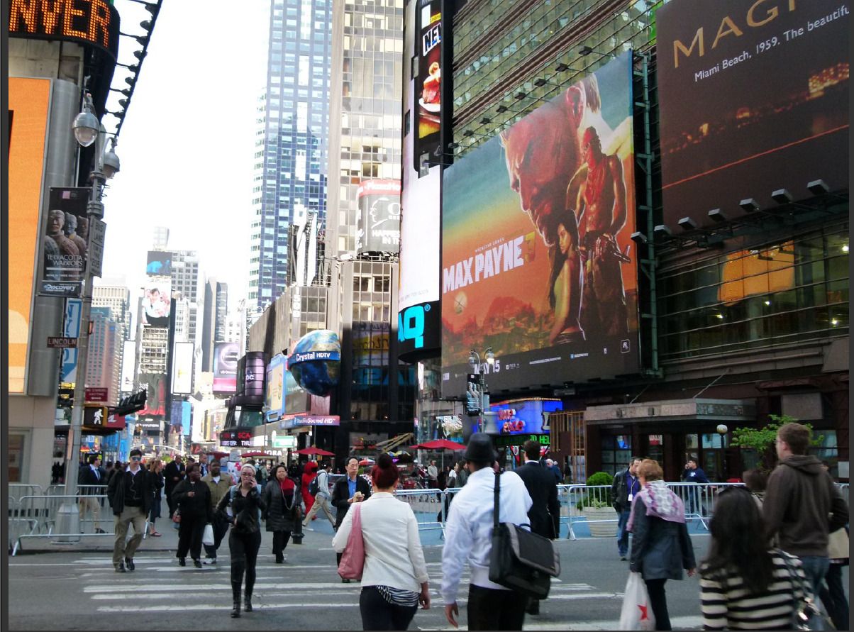 A large Max Payne 3 billboard among other signs in Times Square.